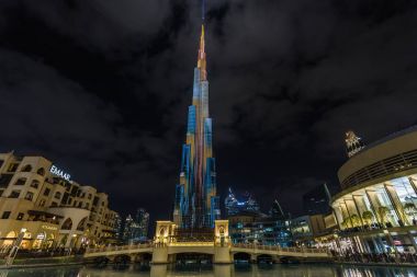 Uluslararası Dubai Kongre ve Sergi Sarayı manzarası ile gece aydınlatma ve Dubai Mall alışveriş merkezine ve Souk Al Bahar yakın bir köprü. Dubai, Birleşik Arap Emirlikleri.