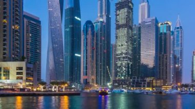 Dubai Yat Limanı en yüksek modern kuleleri ve gün batımında kayan yat ve tekne timelapse gezinti güzel manzarasının.