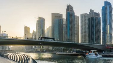 Dubai Yat Limanı en yüksek modern gökdelenler ve kayan yat ve tekne günbatımında hızlandırılmış üzerinde dolgu güzel görünümünden.