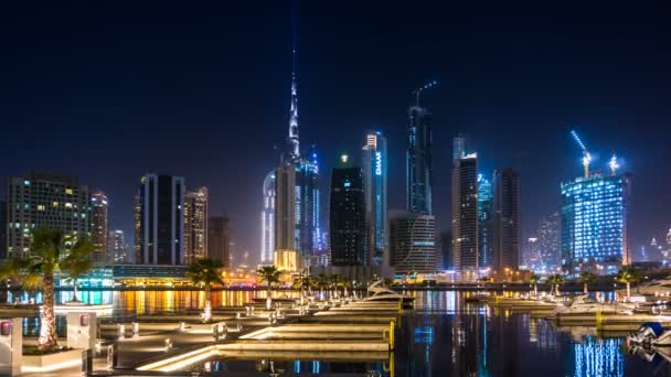 Vista al centro desde el terraplén de Dubai Creek, muelle con yates, lapso de la noche. Dubai, Emiratos Árabes Unidos — Vídeo de stock