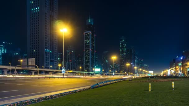 Автомобіль рух на вулиці Шейх Заєд Роуд вночі в центрі міста, хмарочосів з нічного освітлення. Dubai, Об'єднані Арабські Емірати — стокове відео