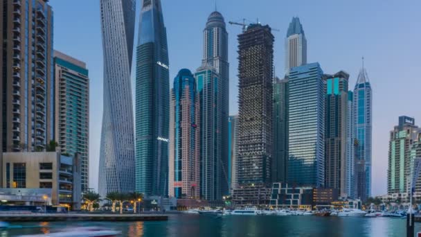 Hermosa vista desde el paseo marítimo en Dubai Marina más alto moderno Torres y yates flotantes y barcos timelapse al atardecer . — Vídeo de stock