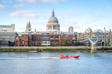 Red speed boat floats on the river Thames past St. Paul's Cathedral. London, UK. clipart