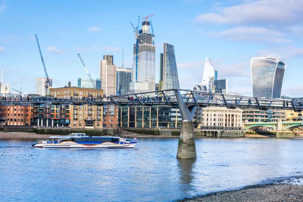 游轮通过千禧桥，以城市摩天大楼为背景。 London, Uk — 图库照片