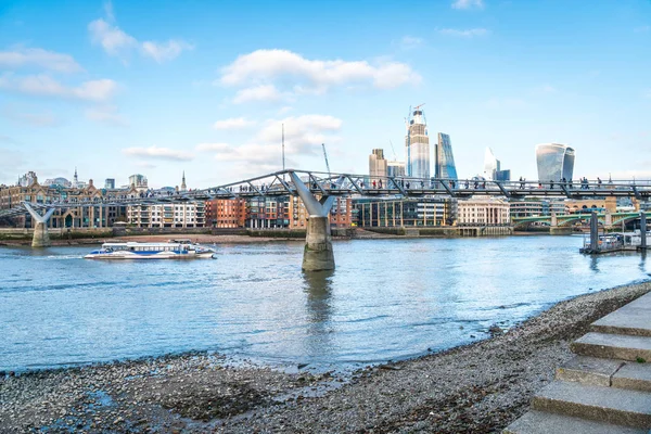 游轮通过千禧桥，以城市摩天大楼为背景。 London, Uk — 图库照片