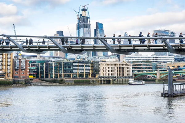 Dagtid London city skyskrapor, Millennium Bridge, floden Themsen, människor promenader. Stockbild