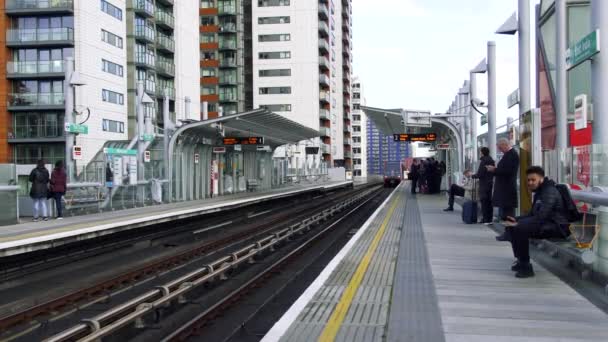 El tren DLR llega a la plataforma de la estación de East India. Los pasajeros entran a los vagones de tren. Londres, Reino Unido . — Vídeo de stock