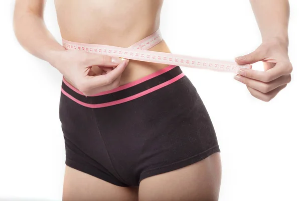 Mujer midiendo su cuerpo delgado sobre fondo blanco. Concepto de salud . —  Fotos de Stock