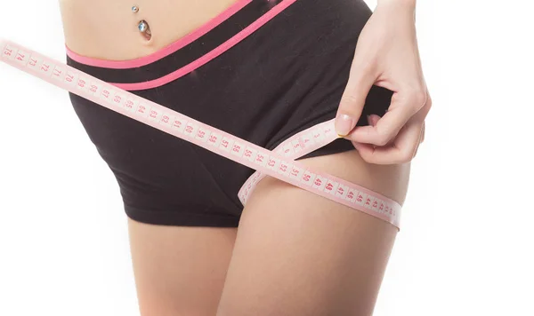 Женщина измеряет свое стройное тело на белом фоне. Концепция здоровья . — стоковое фото