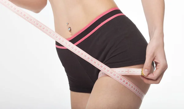 Mujer midiendo su cuerpo delgado sobre fondo blanco. Concepto de salud . — Foto de Stock