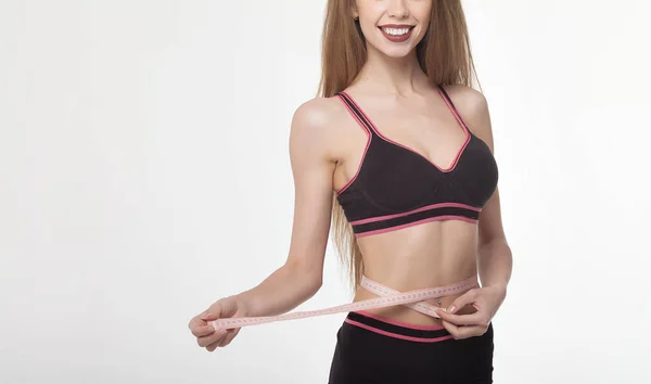 Woman measuring her slim body on white background. Health concept.