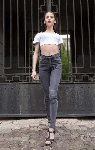 Schöne brünette junge Frau trägt schwarze Jeans — Stockfoto