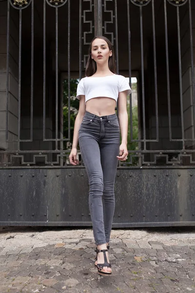 Schöne brünette junge Frau trägt schwarze Jeans — Stockfoto