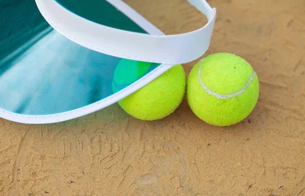 Sandtennisplatz mit Tennisball, Netz, Kappe. — Stockfoto