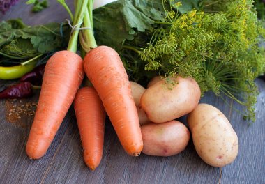 Genç patates ve havuç ahşap arka plan üzerinde