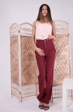 Beyaz arka plan üzerinde trendy bez içinde genç bir kadın tam vücut