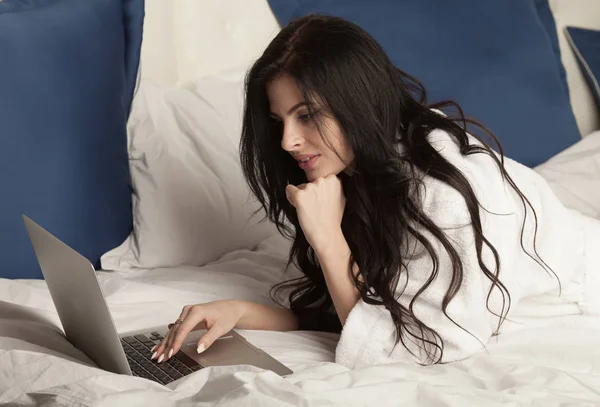 Portrait d'une femme se relaxant à la maison et utilisant un ordinateur portable tout en étant couché au lit — Photo