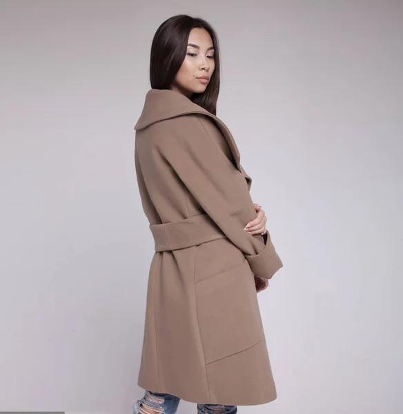 Модна азіатська модель в осінньому/зимовому одязі позує на світлому фоні — стокове фото