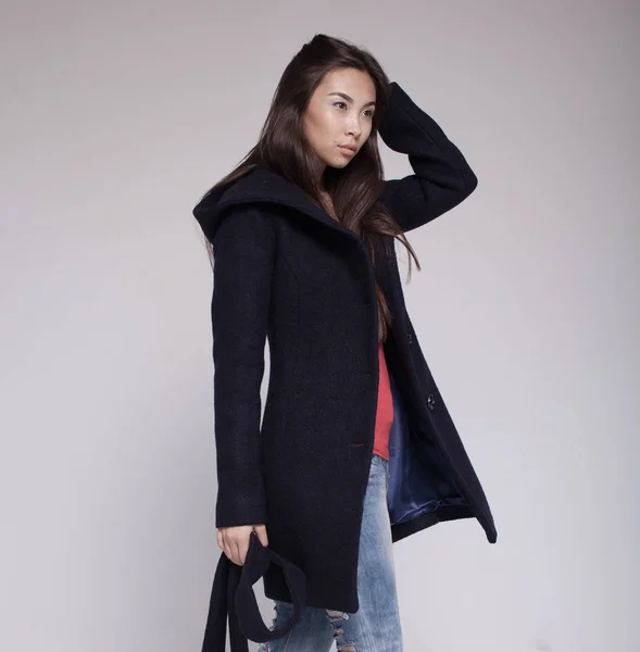 Asijská modelka v oblečení podzim/zima pózuje v světlé pozadí — Stock fotografie