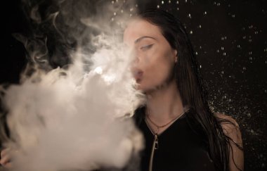 Genç güzel kadın vaping e-sigara. Kadının yüzündeki akan su.