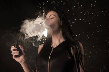 Genç güzel kadın vaping e-sigara. Kadının yüzündeki akan su.