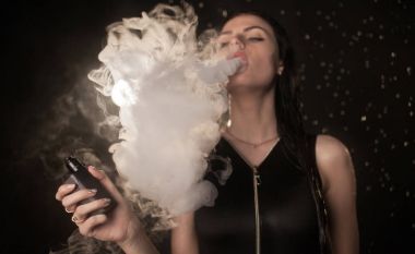 Genç güzel kadın vaping e-sigara. Kadının yüzündeki akan su.