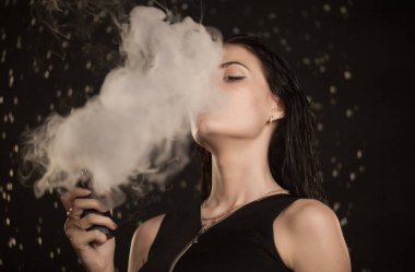 Genç güzel kadın vaping e-sigara. Kadının yüzündeki akan su.