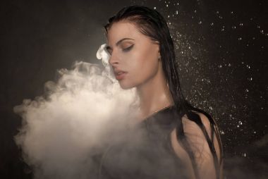 Genç güzel kadın vaping e-sigara. Kadının yüzündeki akan su.