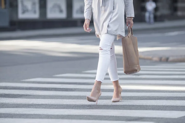 De benen van de vrouw in modieuze schoenen en tas in hand — Stockfoto