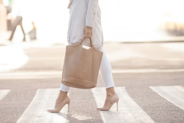 女人的腿在时髦的鞋和手中的包 — 图库照片