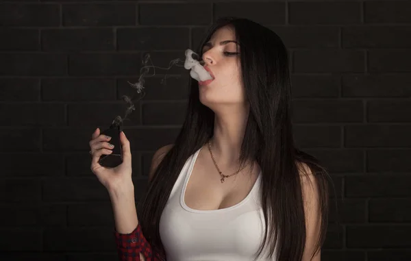 젊은 아름 다운 갈색 머리 여자 흡연, 검은 배경에 연기 vaping 전자 담배. — 스톡 사진