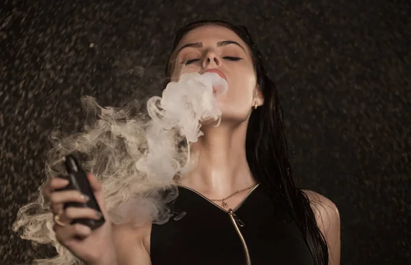 Молода красива жінка пара електронна сигарета. Вода тече на обличчі жінки . — стокове фото