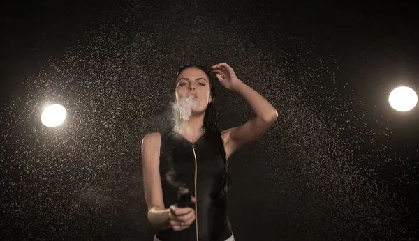 Joven hermosa mujer vapeando cigarrillo electrónico. Agua que fluye en la cara mujer . — Foto de Stock