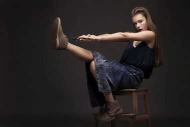 seksi manken doğal esmer saçlı, uzun bacaklı, dolgun dudaklar, mükemmel cilt, kahverengi Ayakkabı ve uzun kot etek giyen, yere, güzellik photoshoot oturma. Kadın ile yaratıcı olun.