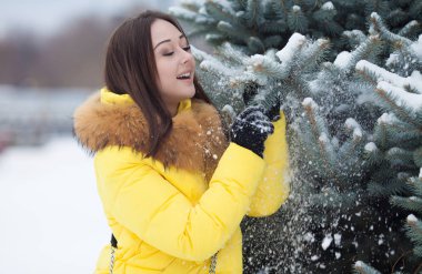 bir kış günü kar taneleri ellerini üzerinden esen, mutlu, güzel genç kadın