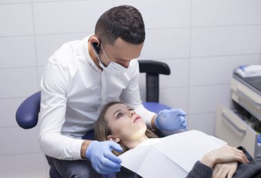 Diş hekimi hastanedeki dişçi kızı tedavi ediyor.