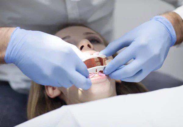 Ο οδοντίατρος περιποιείται την ασθενή με τα δόντια στο νοσοκομείο. — Φωτογραφία Αρχείου