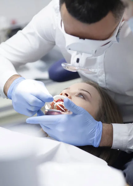 Doctor dentista trata los dientes de una hermosa joven paciente. La chica en recepción en el dentista. Médico dentista trata diente. —  Fotos de Stock