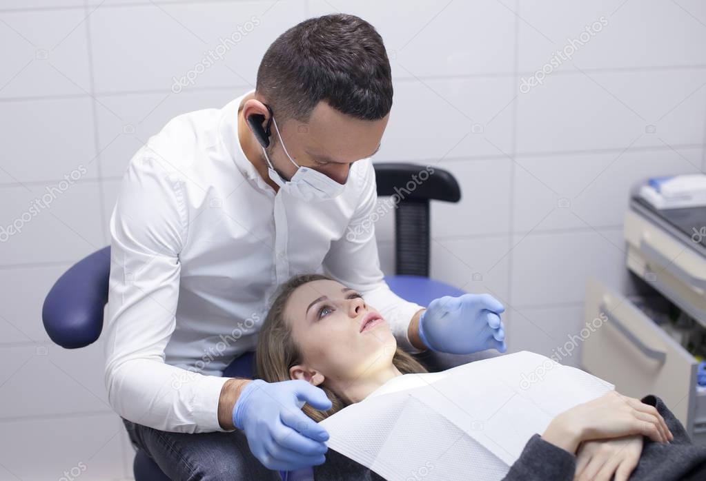 The dentist treats tooth girl patient in hospital office