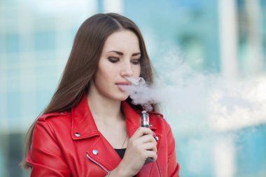 Vaping. Genç güzel kadın (vaping) e-sigara duman açık havada ile. Buharı kavramı.