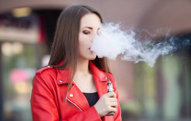 güzel bir kadın (vaping) e-sigara duman açık havada ile. Vaping kavramı.