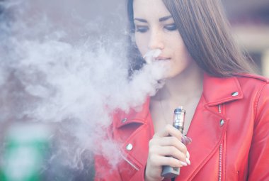 güzel bir kadın (vaping) e-sigara duman açık havada ile. Vaping kavramı.