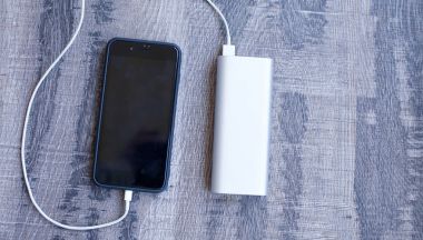 Banka ahşap arka plan üzerinde siyah smartphone ve güç