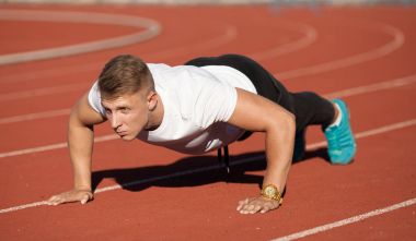 Adam beyaz gömlek stadyum alanında, egzersiz yapmak.