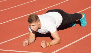 Adam beyaz gömlek stadyum alanında, egzersiz yapmak.