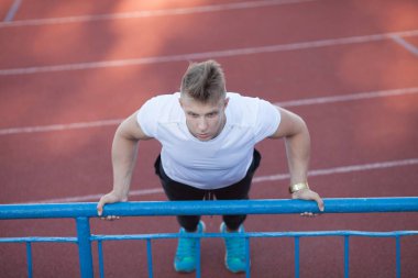 Adam beyaz gömlek stadyum alanında, egzersiz yapmak.