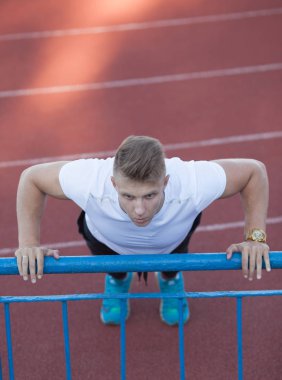 Adam beyaz gömlek stadyum alanında, egzersiz yapmak.