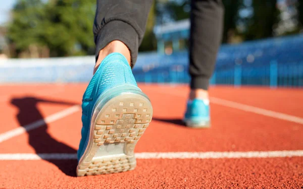 Athlete runner feet running on road closeup on shoe. Man fitness jog workout wellness concept. Man runner legs and shoes in action on road