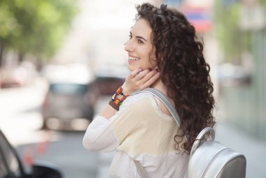 Genç gülümseyen güzel kadın portresi. Taze ve güzel genç moda model poz, yakın çekim portre açık. Yaz açık portre. Kıvırcık saç.