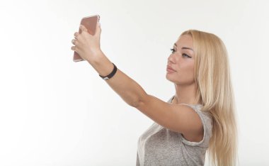 Genç güzel Bayan bir selfie alarak kendini o kameraya gülümseyen kendi kendine portre. Bir smartphone dijital kamera tutan çekici bir kadın portresi kapatın.